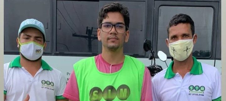 Aluno de colete verde ao lado de dois instrutores da Auto Escola SIM